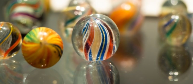 Marble with a blue, red, yellow, and white twist in the middle