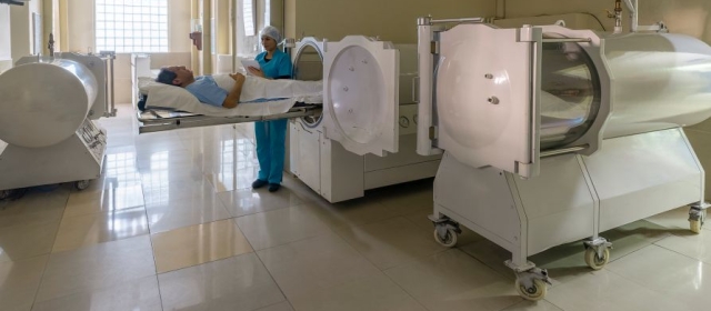 Man laying on hyperbaric chamber bed