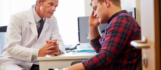 Distressed man speaking with doctor
